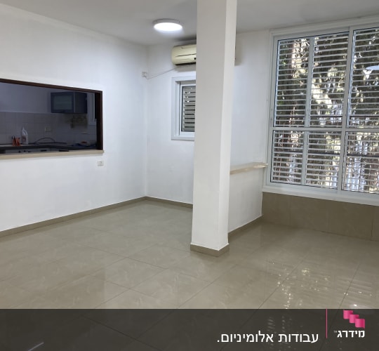 חלון עם תריסי אלומיניום בחדר מואר